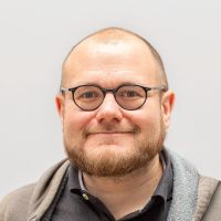 Sebastian Metzger: männlich, bärtig und kleine, runde, schwarze Brille