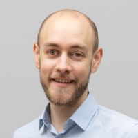 Fabian Streicher – Senior Consultant System Integration: Lächelnder Mann mit Bart und grüngrauen Augen