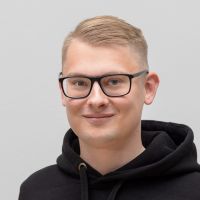 Daniil Dozlov - Data Scientist: Smiling man with short, blond hair and angular, thick, black glasses
