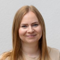 Louisa Yavuz - Online Marketing Manager: Smiling woman with reddish-blonde, shoulder-length hair and blue eyes.