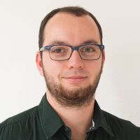 Mathias Ott - QA Manager: Smiling man short, dark brown hair and beard; square, blue glasses.
